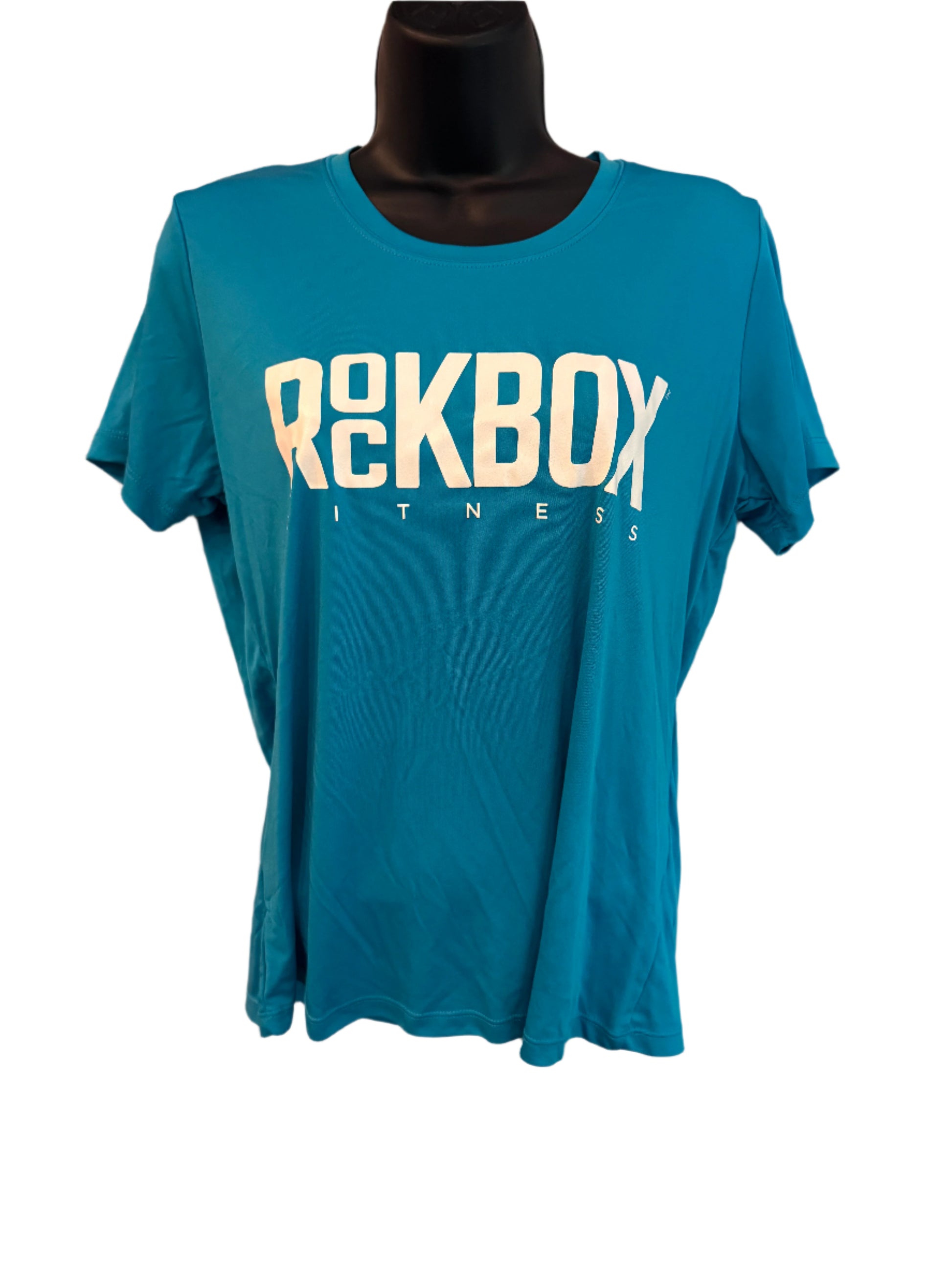 Blue t-shirt with 'REKBOX FITNESS' text on a beige surface