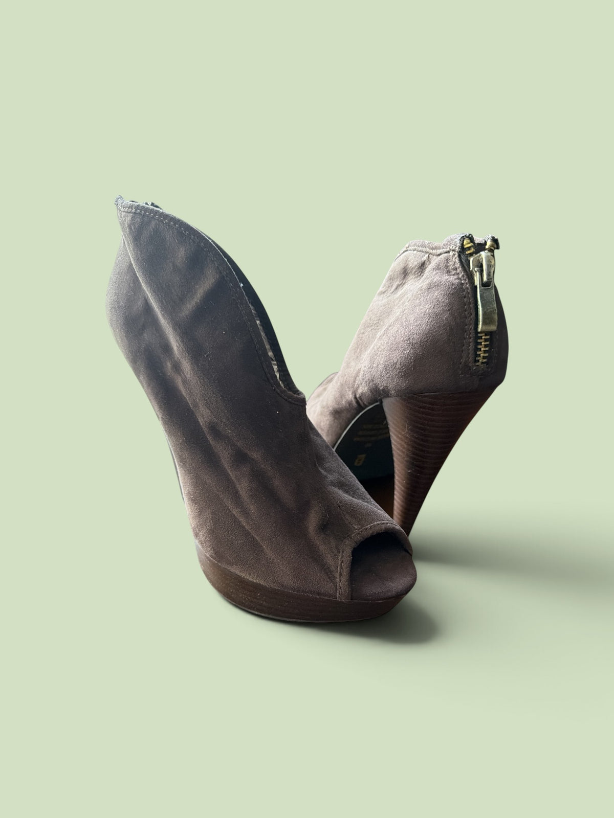 The Xchange taupe-grey faux suede peep-toe ankle booties with a stacked high heel and back zipper closure.