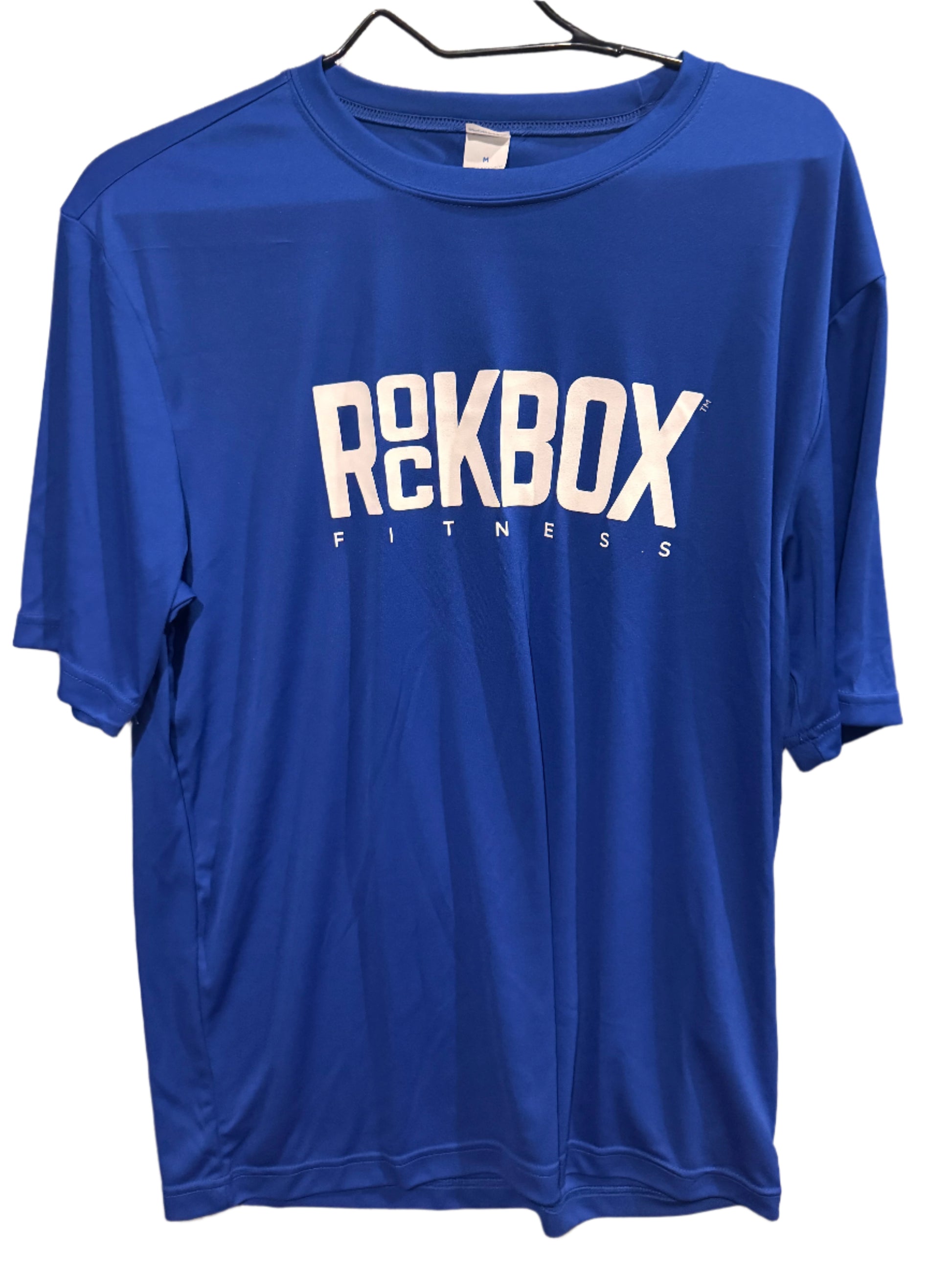 Blue t-shirt with 'ROCKBOX FITNESS' text on a beige surface