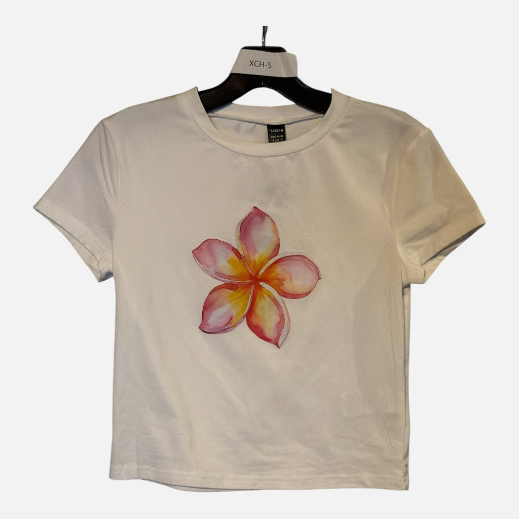 The Xchange white short sleeve crew neck t-shirt featuring a vibrant watercolor plumeria flower graphic on the chest.