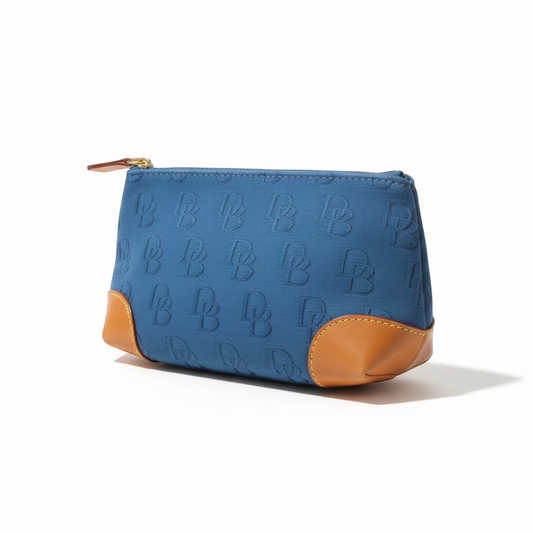 The Xchange Dooney & Bourke blue canvas small tote with tan leather trim and embossed DB logo pattern.