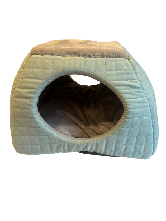 The Xchange small light blue quilted pet bed with plush grey lining and an arched entrance.
