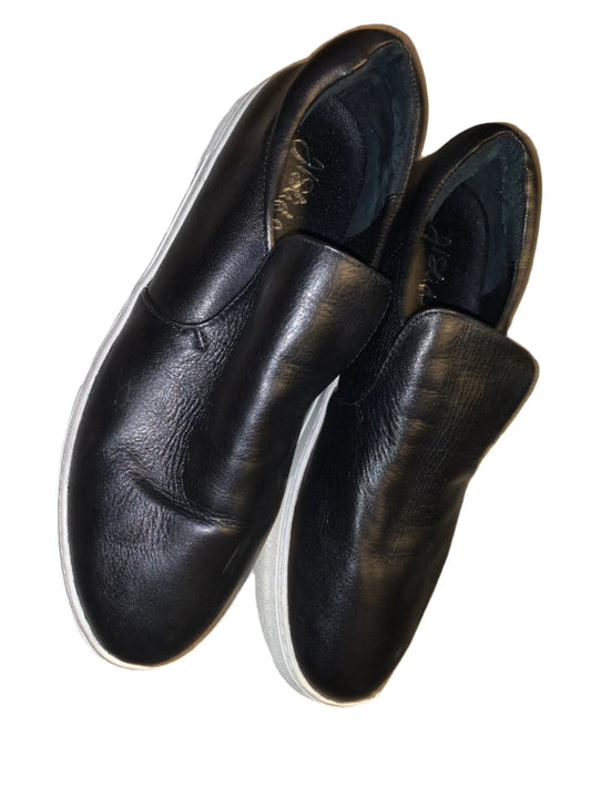 A pair of black leather slip-on shoes by J Slides, size 9.5, displayed against a white background.